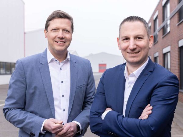 two men in suits standing next to each other